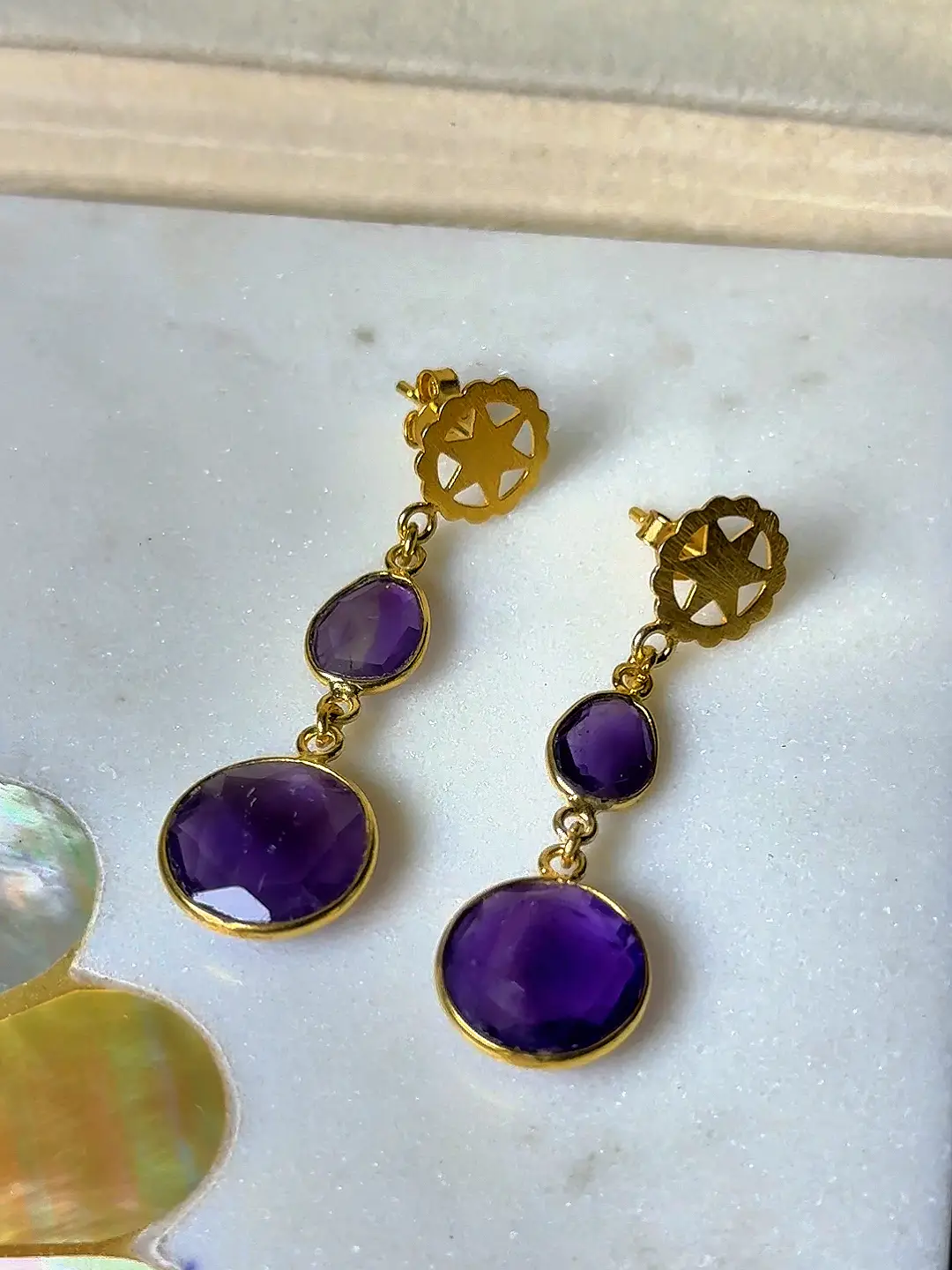 Sandhya gold-plated silver drop earrings with two graduated faceted amethysts and a pierced gold rosette stud